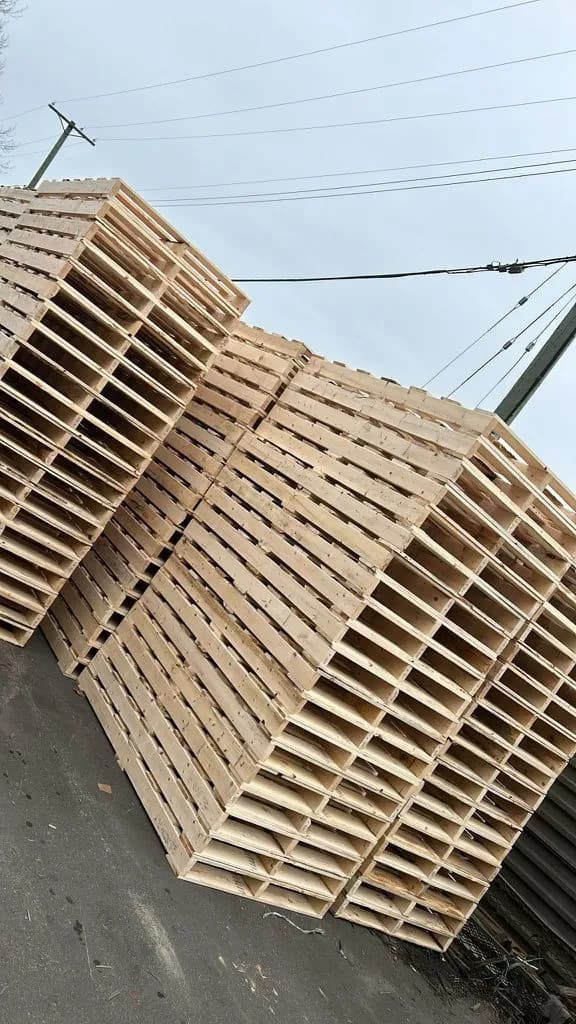 Large outdoor stack of wooden pallets